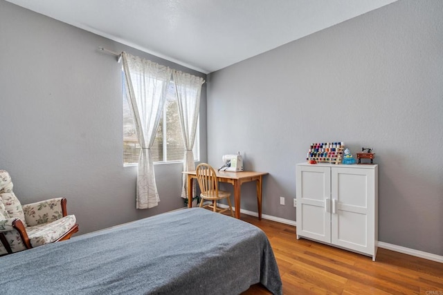 bedroom featuring baseboards and wood finished floors