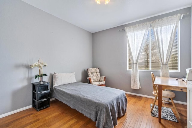 bedroom featuring light wood-style floors and baseboards