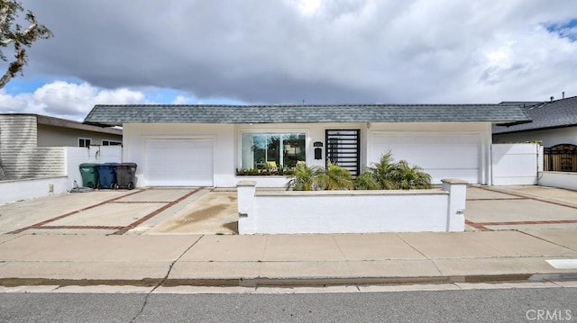 view of front of house with roof with shingles, concrete driveway, and an attached garage