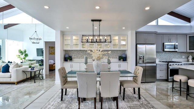 dining area with plenty of natural light, recessed lighting, marble finish floor, and a chandelier