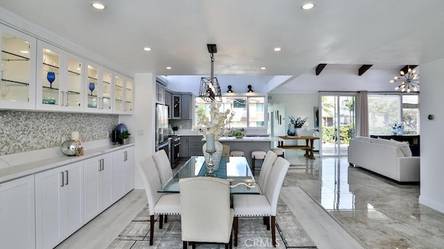 dining space featuring recessed lighting, marble finish floor, and an inviting chandelier