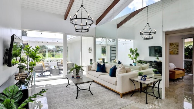 living area with beamed ceiling, a notable chandelier, and high vaulted ceiling