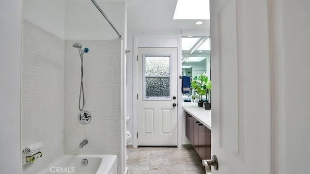 bathroom with a skylight, toilet, shower / washtub combination, and vanity