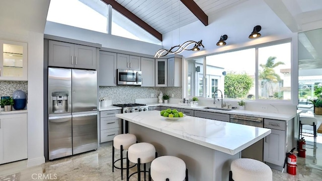 kitchen with a sink, stainless steel appliances, and gray cabinetry