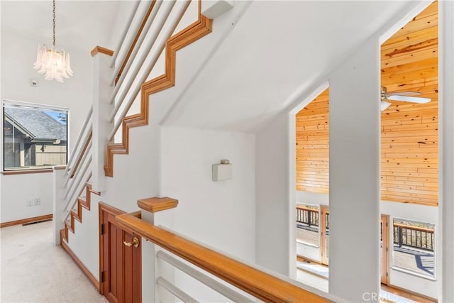 staircase with vaulted ceiling, baseboards, an inviting chandelier, and carpet floors