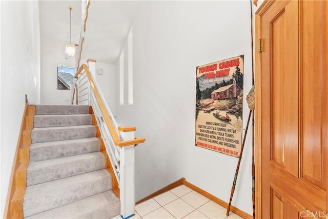 stairway featuring tile patterned flooring and baseboards