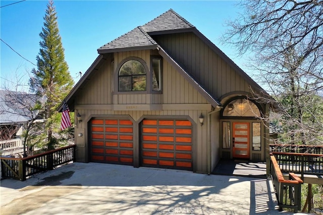 view of front of house featuring a garage, roof with shingles, and driveway