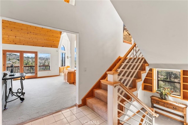 staircase with tile patterned floors, carpet flooring, a healthy amount of sunlight, and baseboards