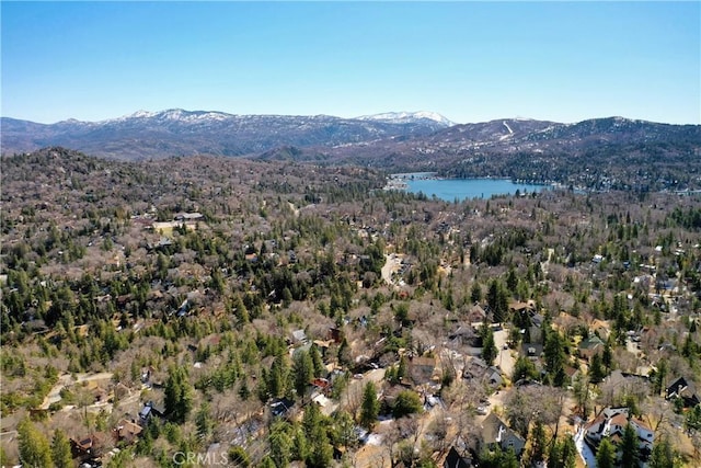 aerial view featuring a wooded view and a water and mountain view