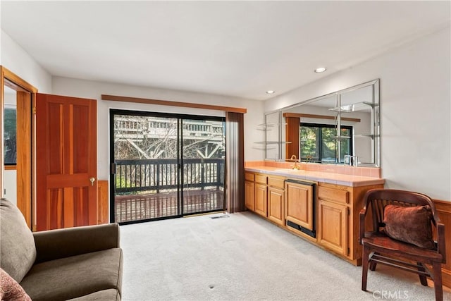 interior space featuring recessed lighting, light colored carpet, and a sink