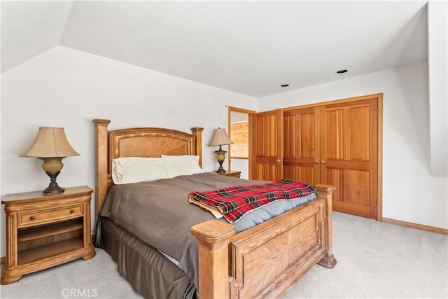 bedroom featuring baseboards, light carpet, and vaulted ceiling