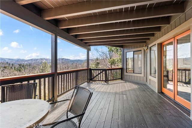 deck with outdoor dining space and a mountain view