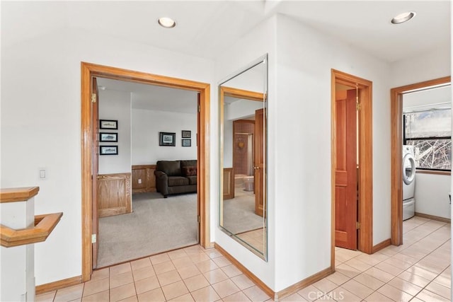 hall featuring light carpet, recessed lighting, washer / dryer, and light tile patterned floors