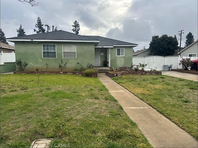 bungalow-style home featuring a gate, stucco siding, a front lawn, and fence