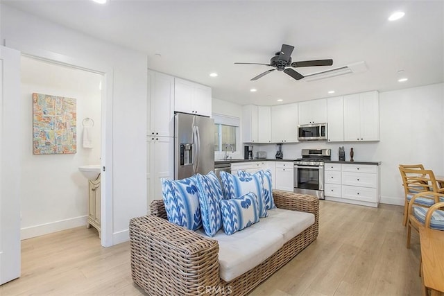 living room with recessed lighting, baseboards, ceiling fan, and light wood finished floors