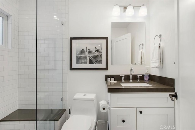 full bath with vanity, toilet, and a tile shower