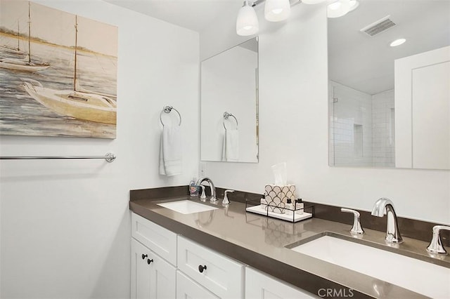 bathroom featuring double vanity, visible vents, recessed lighting, and a sink