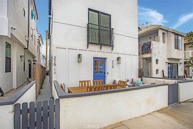 property entrance featuring stucco siding and fence