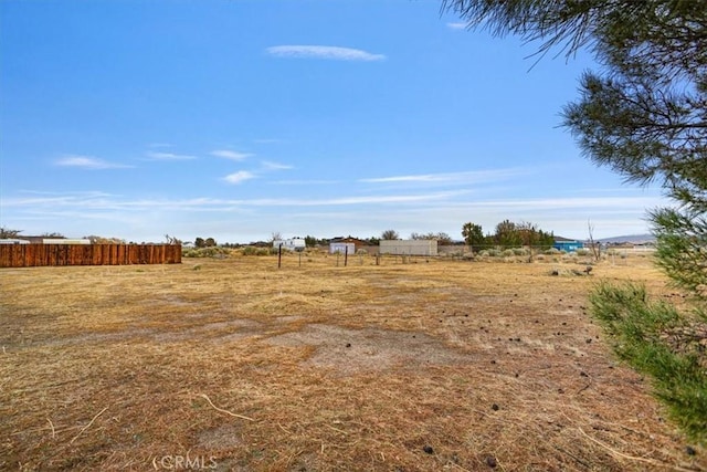 view of yard with a rural view and fence