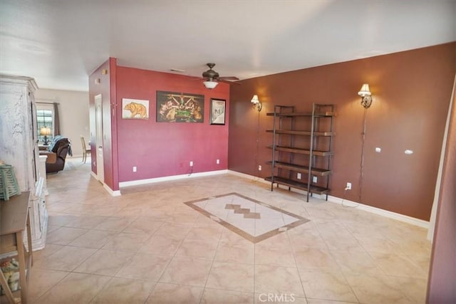 interior space featuring light tile patterned flooring, baseboards, and ceiling fan