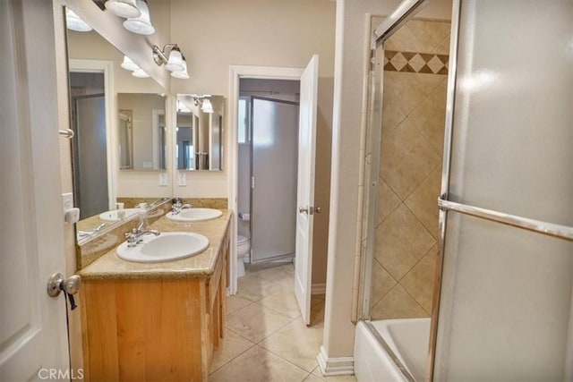 full bathroom with tile patterned flooring, double vanity, toilet, and a sink