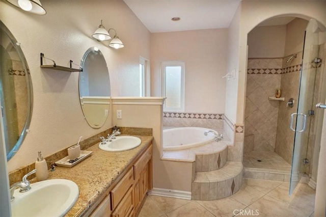 bathroom featuring a bath, a shower stall, tile patterned floors, and a sink