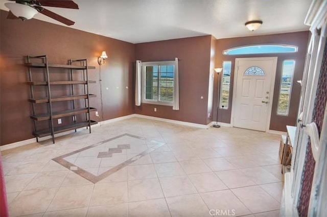 entrance foyer featuring light tile patterned floors, a ceiling fan, and baseboards