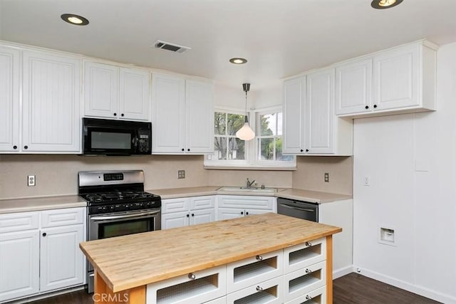 kitchen with visible vents, butcher block countertops, white cabinets, black appliances, and a sink