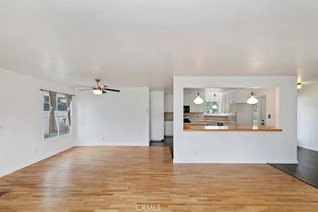 unfurnished living room featuring light wood finished floors and ceiling fan