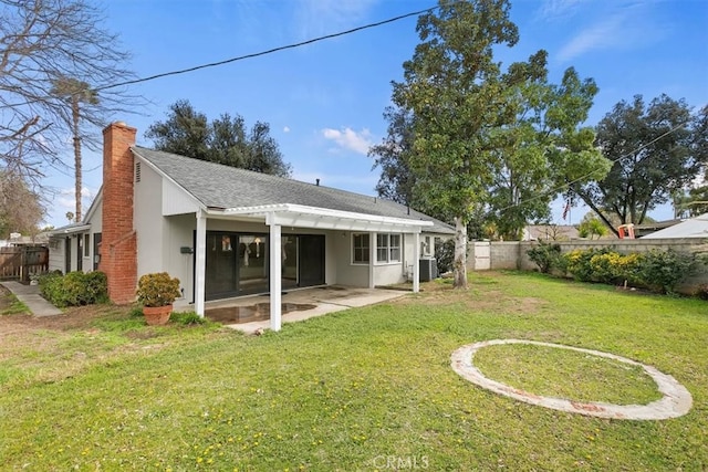 back of house featuring a fenced backyard, a chimney, central air condition unit, a patio area, and a lawn