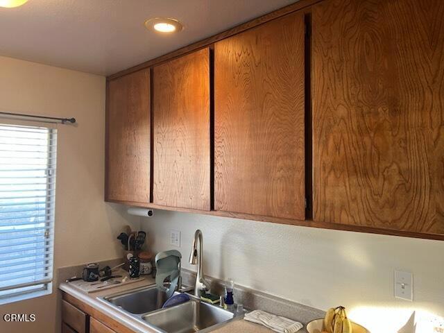 kitchen with a sink, brown cabinetry, and light countertops