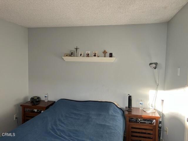 bedroom with radiator and a textured ceiling