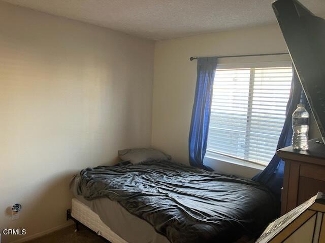 bedroom with multiple windows and a textured ceiling