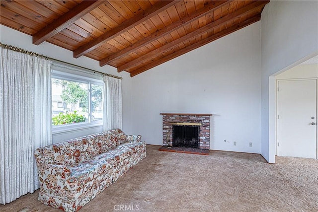 unfurnished living room featuring beam ceiling, a fireplace, wooden ceiling, and carpet flooring