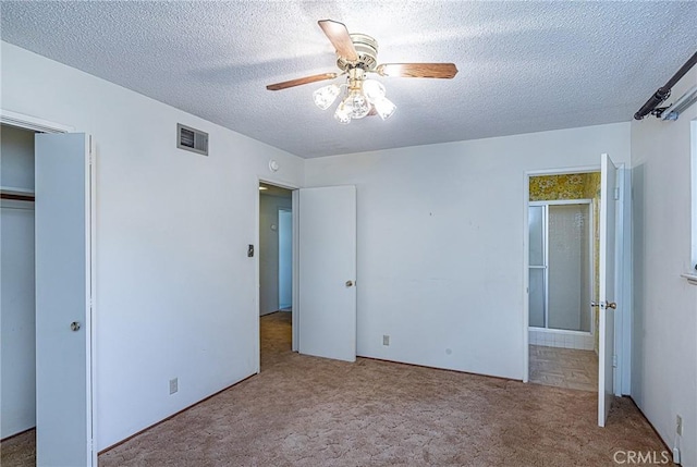 unfurnished bedroom featuring a ceiling fan, visible vents, carpet floors, a closet, and a textured ceiling