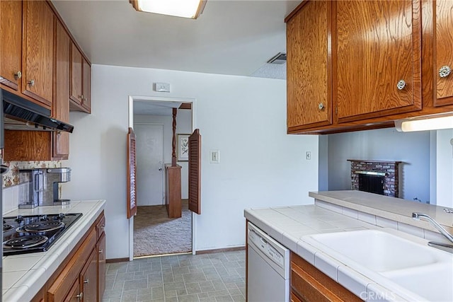 kitchen featuring a sink, brown cabinets, black electric stovetop, and white dishwasher