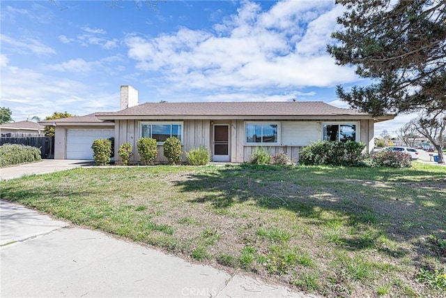 ranch-style home featuring a front yard, fence, driveway, a chimney, and a garage