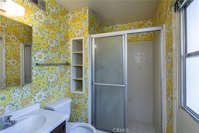 full bath featuring wallpapered walls, a shower stall, toilet, and vanity