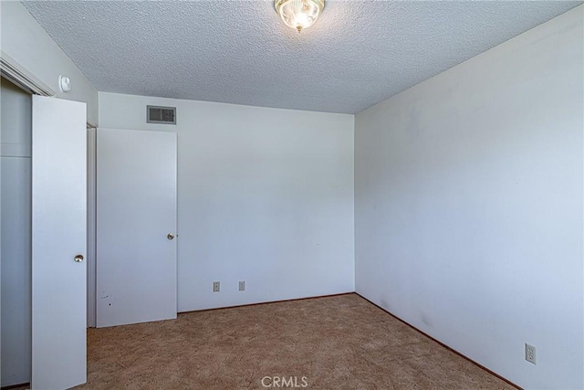 unfurnished bedroom with visible vents, a textured ceiling, a closet, and carpet flooring