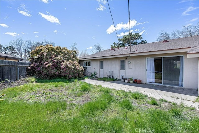 back of house featuring stucco siding and fence