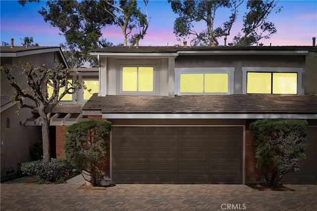 view of front of property with a garage, decorative driveway, and stucco siding