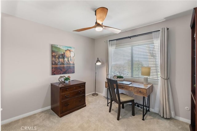 office featuring light carpet, baseboards, and a ceiling fan