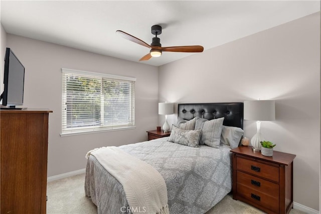 bedroom with ceiling fan, baseboards, and light carpet