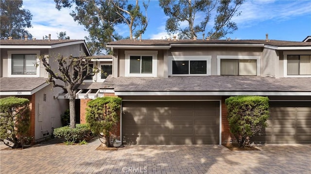 townhome / multi-family property featuring stucco siding, driveway, and an attached garage