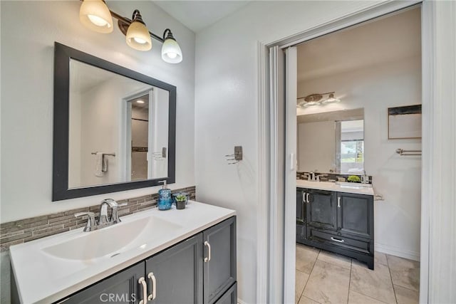 bathroom with decorative backsplash, two vanities, and a sink