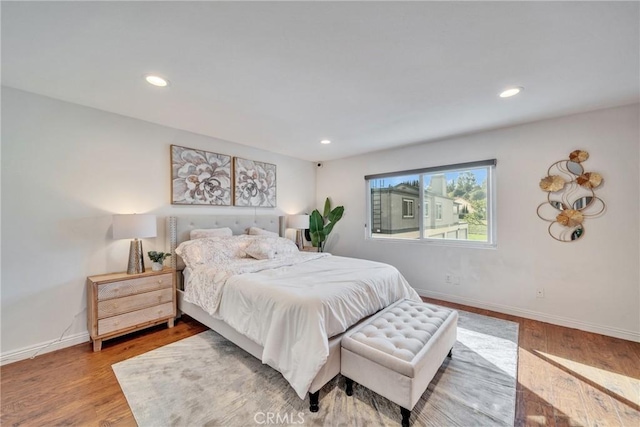 bedroom with recessed lighting, wood finished floors, and baseboards