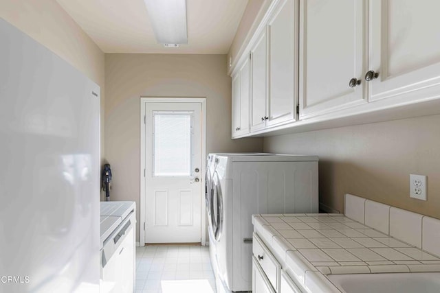 washroom with cabinet space and washing machine and dryer