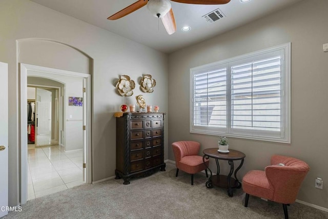 sitting room featuring visible vents, baseboards, carpet, arched walkways, and a ceiling fan