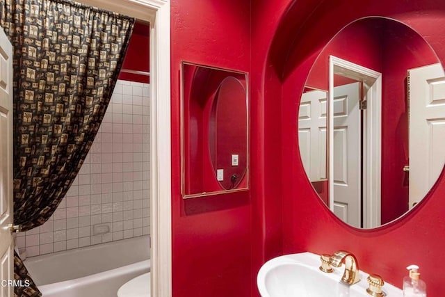 full bathroom featuring  shower combination, toilet, a textured wall, and a sink