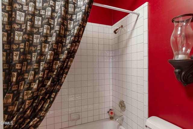 bathroom with shower / bath combination with curtain and toilet